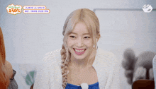 a girl with blonde hair is smiling in front of a sign that says " stayg "