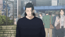 a man in a black shirt stands in front of a crowd