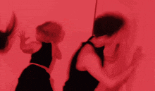 a group of dancers are performing in front of a red backdrop