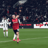 a soccer player wearing a red shirt that says barmeni on it