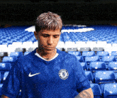 a man wearing a blue nike shirt with a chelsea logo on it