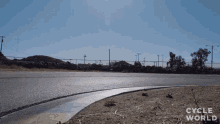 a road with the words cycle world on the bottom right