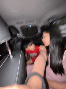 a blurry picture of two people in a car with one wearing a red shirt that says california