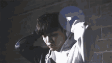 a man wearing a white hoodie with a monster logo on it