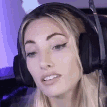 a woman wearing headphones is sitting in front of a computer screen .