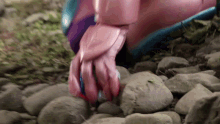 a close up of a robot 's hand on a pile of rocks .
