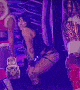 a woman is dancing on a stage with a man in a santa claus costume in the background .