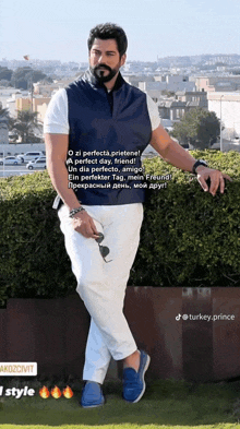a man with a beard is wearing a blue vest