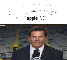 a man in a suit and tie is talking into a microphone in front of a fox logo .