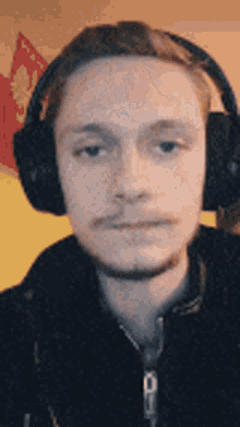 a man wearing headphones is taking a selfie .