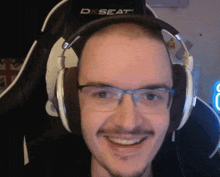 a man wearing headphones with a d seat logo on the back of his chair