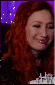 a woman with red hair is making a funny face