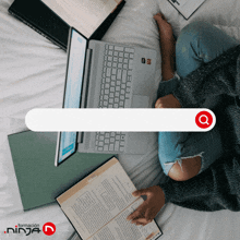 a person sitting on a bed with a laptop and a book with a search bar in the middle