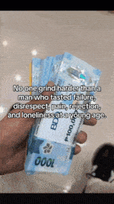 a hand holding a stack of 1000 bills