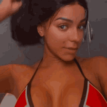 a woman in a bikini is adjusting her bra straps