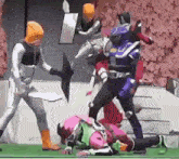 a group of power rangers are fighting each other on a field .