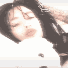 a girl is laying on a bed with a teddy bear in her lap .
