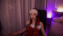 a woman wearing a santa hat and headphones sitting in a chair