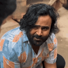 a man with long hair and a beard wearing a shirt that says happy
