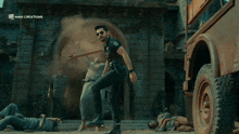 a man in a police uniform is dancing in front of a building that says mani creations on it