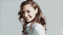 a close up of a woman wearing a denim shirt smiling .