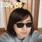 a woman wearing sunglasses has a bun in her hair and the word doll is on the bottom