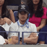 a man wearing a black hat that says austin indie studios sits in the stands