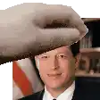a man in a suit and tie is being patted on the head by a hand .