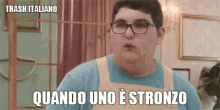 a young man wearing glasses and an apron says trash italiano quando uno è stronzo