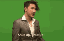 a man in a suit is saying shut up