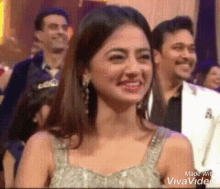 a woman is smiling in front of a group of people .