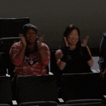 a man and two women are sitting in a theatre laughing