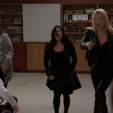 a group of women are dancing in a room with a white board that says ' a.m. ' on it
