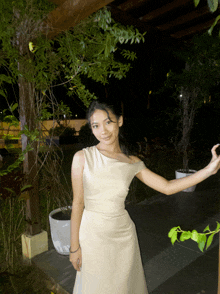 a woman in a white dress is posing for a photo