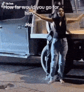 a woman is standing in front of a truck with her arms outstretched and a caption that says would you go for him .