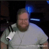 a man with a beard and glasses is sitting in front of a microphone ..