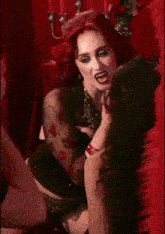 a woman with red hair is biting another woman 's neck