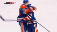two hockey players are hugging each other during a game between the edmonton oilers and the toronto maple leafs