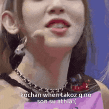 a close up of a woman 's face with the words kochan when takoz q no son su athia written on it .