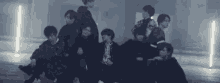 a group of young men are standing in a dark room .