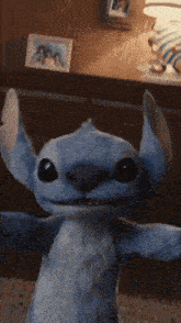 a stuffed animal with its arms outstretched is standing in front of a dresser