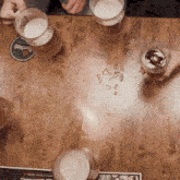 four glasses of beer are on a wooden table with a coaster that says pilsner urquell on it