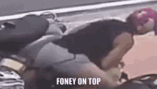 a person is laying on top of a motorcycle with the words `` foney on top '' written on the bottom .
