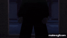 a man in a hooded jacket is standing in a doorway at night .