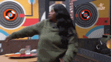 a woman dancing in front of a sign that says estrella de cara