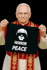 a priest is holding up a black sign that says honor peace