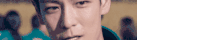 a close up of a man 's face looking at the camera with a blurry background .