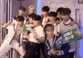 a group of young men are posing for a picture and one of them is holding a sign that says ' mbc '