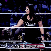 a woman in a wrestling ring with the name sage beckett on the banner