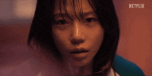 a close up of a woman 's face with netflix written on the bottom